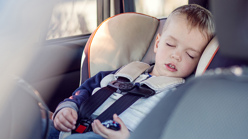 bambino dorme in seggiolino auto
